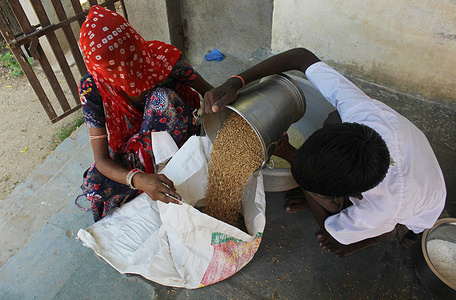 A guardian receives free ration her sack distributed under the Midday Meal Scheme, at a state-run school, in a village of Pali district in the western Indian state of Rajasthan.
The Midday Meal Scheme, a school meal program in the state-run upper primary schools by the Government of India, has been put off since mid-March this year due to the closure of schools and other educational institutions following the nationwide lockdown, imposed to contain the novel corona virus disease (COVID-19). Under this newly approved plan, the government is providing around 5 kilograms and 7 kilograms of free food grains for classes 1-5 and 6-8 respectively for the months of July and August, 2020, as per an official data released by the office of District Education Officer at a state-run school, in a village of Pali district in the western Indian state of Rajasthan.