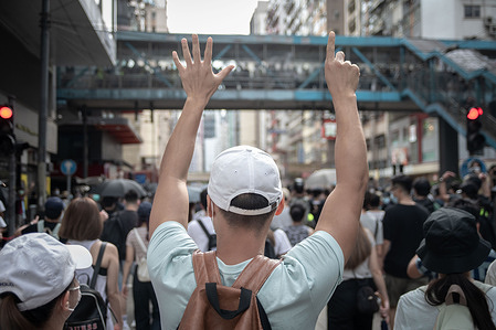 A protester marching in defiance of police ban despite security law, whilst raising their hands up to signal “Five demands, not one less".
Activists and protesters have hit the streets of Hong Kong in a reaction to the National Security Law imposed on the autonomous region by the central government in Beijing. The date also marked the 23rd anniversary of the handover of the former British colony to China. Riot police were deployed on the street to prevent the protesters from joining on the traditional parade.