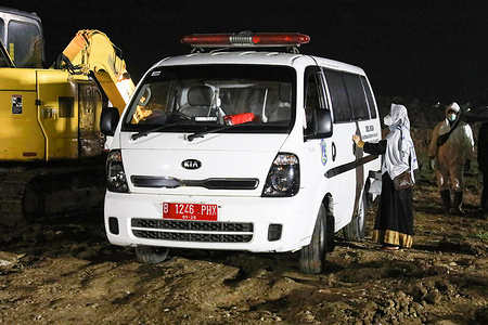 A relative paying last respects to a covid 19 victim inside an ambulance at the Rorotan Public Cemetery.The trend of daily Covid-19 cases in Indonesia has increased since the beginning of June 2021.