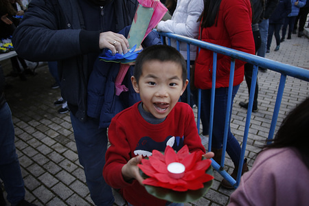 A kid seen carrying a lotus flower during the festival.
People gathered at Lake Prodolongo to witness the inauguration of the new Chinese year with fireworks, in ancient times they were traditionally lit to scare away the monster Nian, half dragon, half lion, who, according to legend, attacked the villagers and sometimes devoured children, but could be chased away with loud noises. In addition, they distanced the evil spirits, which otherwise could bring bad luck.