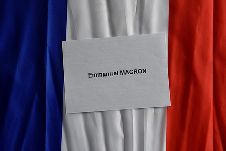 In this photo illustration, a ballot of Emmanuel Macron is seen on a French flag for the second round of the 2022 French presidential election. On Sunday, April 24, 2022, French voters will choose their president for the next five years. The duel will oppose, as in 2017, the far right candidate Marine Le Pen of the "Rassemblement National" party (RN) to the outgoing president Emmanuel Macron of the "La Republique En Marche" (LREM).