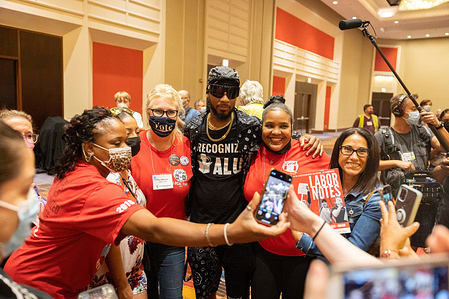Labor leader Chris Smalls, center, president of Amazon Labor Union, poses for photos with union members during the Labor Notes conference, in Chicago.