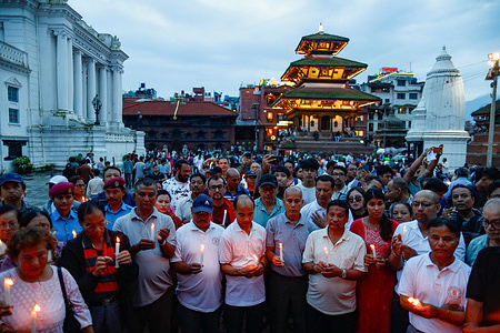 People light candles during a candlelight vigil at Basantapur Durbar Square in memory of those who lost their lives in the devastating flash floods and landslides. The city is observing a national day of mourning as the death toll from the disaster has reached at least 1,355 people, with 4,996 people still missing and 13,396 rescued, according to authorities.