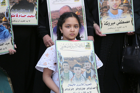 A Palestinian girl holds a poster of her three brothers imprisoned in Israeli jails during a march in the West Bank city of Nablus protesting Israel's new death penalty law, which allows for the execution of Palestinians convicted of carrying out deadly attacks. Under the new law, passed by the Israeli parliament in March, those convicted by military courts of carrying out deadly attacks against Israeli citizens will be executed.