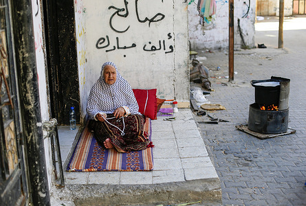 An elderly Palestinian woman sits in front of her home in Jabalia refugee camp in the northern Gaza Strip.