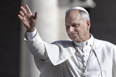 Pope Leo XIV waves to the faithful as he arrives for his weekly general audience in St. Peter's square at the Vatican.