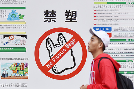 A University student walks past a poster banning plastic bags in Haikou.
Starting December 1, China's Hainan will ban the production, sale and use of a wide range of disposable plastic products, according to the regional ecology department.
