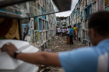 Relative's gather around the allotment allocated to Adonis Dela Rosa before his burial. Dela Rosa was killed by police during a 'buy-bust' operation. Police allege he was a gun-for-hire, however his wife strongly denies the claim.
The drug war in the Philippines, initiated by President Rodrigo Duterte, has led to the deaths of more than 12,000 drug users at the hands of police and vigilante killers since it kicked off in July 2016. The killings have received vociferous support locally but widespread condemnation internationally.