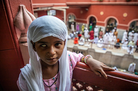 A visually impaired Muslim girl poses for a picture in a mosque after attending the last Jumma Namaz during the month long observation of Ramadan.