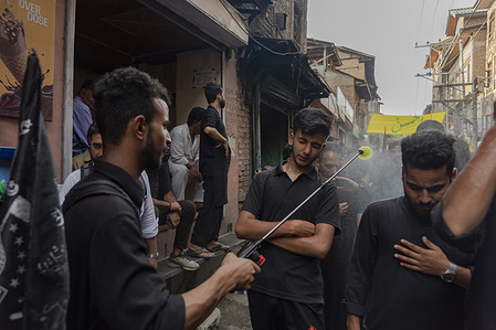 A Shia man sprays rose water on mourners during a religious procession on the 5th day of Muharram. Muharram is the first month of Islam. It is one of the holiest months on the Islamic calendar. Shia Muslims commemorate Muharram as a month of mourning in remembrance of the martyrdom of the Islamic Prophet Muhammad's grandson Imam Hussain, who was killed on Ashura (10th day of Muharram) in the battle of Karbala in 680 A.D.