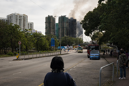 The local residents are seen spectating the burning towers in Wang Fuk Court. On Wednesday 26th November, a tower in Wang Fuk Court, which is an eight-tower complex in Tai Po, Hong Kong, had caught fire, while the complex had been under renovation, the towers were clad in bamboo scaffolding and mesh, it led to the rapid spread of the deadly fire to the other six towers. The incident soon escalated to Level 5 fire, for the first time in 17 years. After an overnight rescue operation by firefighters and police force, the fire was reportedly under control. The death toll has been rising following the continuation of the rescue work. Many local residents have also volunteered to allocate and deliver emergency supplies to displaced residents of the complex.