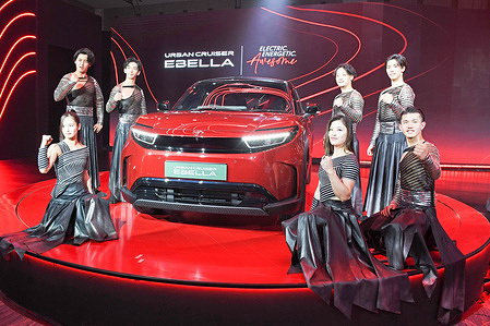 Drum Tao performers seen posing for a photo with Toyota electric Urban Cruiser Ebella car during its launch event.