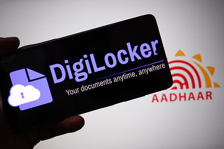 In this photo illustration, a Digi locker logo is seen displayed on a smartphone with an Aadhar logo in the background.