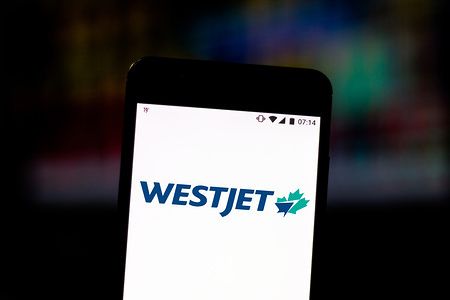 In this photo illustration the WestJet Airlines logo is displayed on a smartphone.