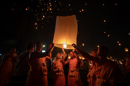 Monks release floating lanterns during the Yi Peng festival celebrations at Lanna Dhutanka in Chiang Mai, Thailand. The ancient northern traditional festival is held annually to celebrate the full moon of the twelfth month in the Thai lunar calendar by launching floating lanterns into the night sky, with the belief that misfortune will fly away with the lanterns as part of the Loy Krathong celebration.