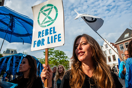 A woman holds a placard that says rebel for life while shouting slogans during the protest.
Around thirty people and activists gathered at the town hall in the Dutch city of Utrecht where some political parties are going to vote over a motion of the PvdD (political party for animals in the Netherlands) to explain and declare a climate emergency in The Netherlands. Outside of the city hall was surrounded by the police, people wearing blue clothes while making noise with different objects, also screaming to declare a Climate Emergency.