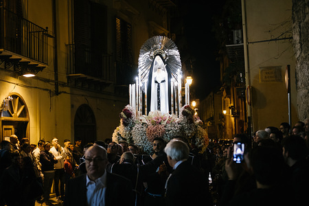 The statue of the Holy Mary approaches, carried on shoulder, in front of the church of cocchieri, where it left few hours before. On the holy Friday before Easter many processions fill the streets of Palermo, the capital of Sicily region in southern Italy. Religious celebrations are very important moments deeply felt among the people. The processions of the Holy Friday have normally two figures Jesus and the Holy Mary. The processions re enact the trip taken by the Holy Mary after the crucifixion of Jesus to take his body to the sepulchre. The religious processions are meant to visit different neighbourhood of the city before returning back to the starting church, after some hours.