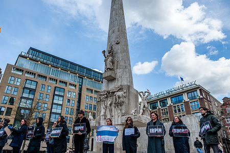People wearing black clothes are seen at the Dam square holding placards with the names of the Ukrainian cities attacked by the Russian army. After the terrible events that happened in Bucha (Ukraine) this week, the Russian community in The Netherlands organized a vigil of grief to commemorate the victims of the Russian Federation atrocities. People gathered at the Dam square wearing black clothes and holding placards with the names of the Ukrainian cities attacked by the Russian army,. The event was a silent mourning action with no announcements or speeches.