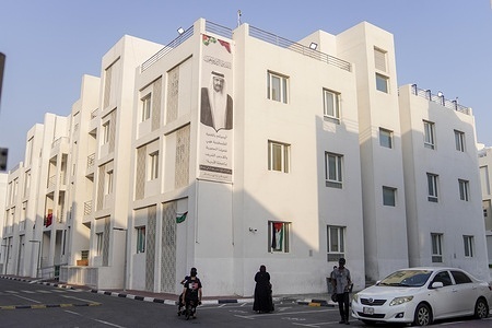 People seen walking past a portrait of the late Emir, Sheikh Hamad bin Khalifa Al Thani, on the building of the Al Thumama complex.. Qatar has declared a four-day period of national mourning following the passing of the former Emir, Sheikh Hamad bin Khalifa Al Thani, at the age of 74. The former Emir—who assumed power in June 1995—is regarded as the principal architect of modern Qatar; he is renowned for transforming the Gulf state into an influential global power during a period marked by unprecedented economic development, expanding diplomatic influence, and rapid infrastructure growth.
Injured individuals from Gaza have displayed portraits of the late Emir, Sheikh Hamad bin Khalifa Al Thani, on the buildings of the Al Thumama complex in Doha,