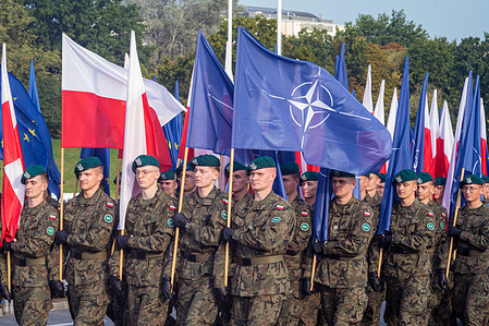 Polish soldiers march with Polish, NATO and European Union flags. Poland's Minister of National Defence, Władysław Kosiniak-Kamysz, held a press conference following rehearsals for the upcoming Polish Armed Forces Day parade. The parade was set to be a major event, featuring over 4,000 soldiers, 300 military vehicles, and 50 aircraft, with a naval component on the Hel Peninsula.