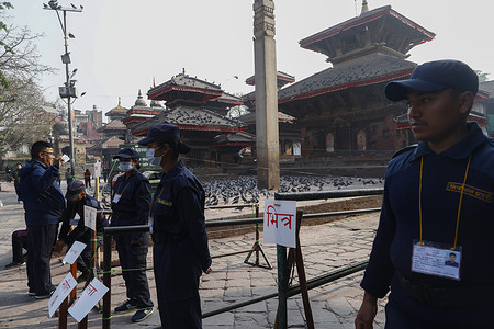 Police conduct security checks on voters before they cast their ballots at a polling booth during the elections in Kathmandu.
