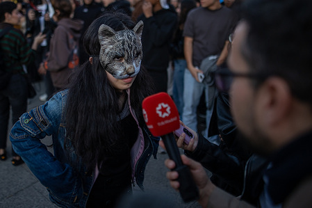 A young woman wearing a cat mask speaks to the press during a Therians gathering in the center of Madrid. A gathering organized through social media at Puerta del Sol in Madrid for therians. Therians are people who identify, on a psychological or spiritual level, with a non-human animal. It is a social and cultural phenomenon that does not involve a physical transformation or the belief of possessing a different body, but rather an internal experience of identity.