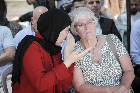 A Palestinian woman translates from Arabic to English for a German Norgark of the German Embassy for Development and Humanitarian Aid during the opening of the Akhliya Association in the northern Jordan Valley, which supports Palestinian youth and women in their resilience against attacks by Jewish settlers in the northern Jordan Valley near the West Bank.