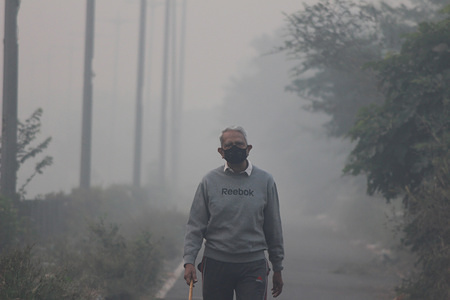A man wearing a protective mask jogs on a foggy morning in Noida on the outskirts of New Delhi.
The air quality in Delhi-NCR remained in "severe" category on Friday morning. Supreme Court-mandated anti-pollution authority and ordered closure of schools in Delhi-NCR for the next two days on (14th & 15th November) as pollution in the region hovered close to emergency levels.