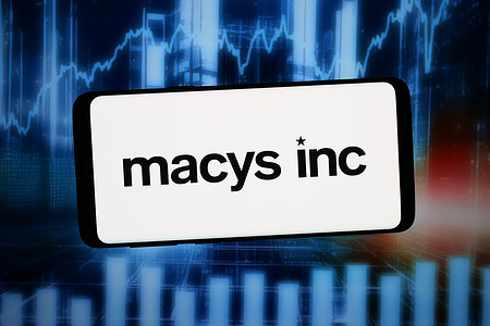 In this photo illustration, the logo of department store company Macy's Inc. (Macys) is displayed on a smartphone in front of abstract background on computer screen.