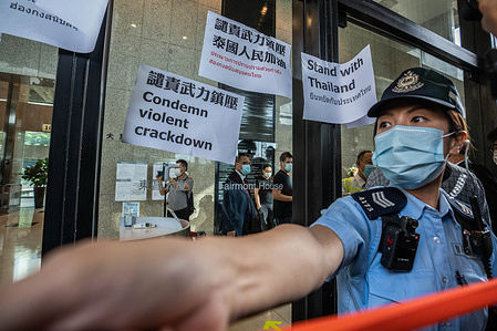 A female police officer stands guard outside the Embassy of Thailand as activists demonstrated in solidarity with ongoing pro-democracy protests in Thailand
Dozens of Pro-Democracy activists from Hong Kong gathered outside the Embassy of Thailand to show solidity with the Thai anti government protesters and condemn the violent crackdown against the protesters by the Thai government.