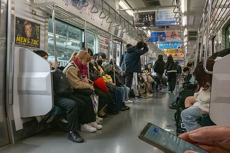 Passengers sit and stand inside a crowded commuter train during daily travel. Shinjuku Station in Tokyo is the busiest railway station in the world, serving millions of passengers each day across multiple train and subway lines. Its vast network of platforms, exits, and underground passages connects major commercial, business, and entertainment districts throughout the city.