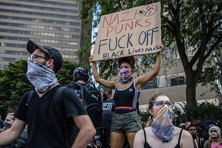 (EDITORS NOTE: Image contains profanity) A counter protester holds a placard written on it 'Nazi Punks Fuck Off, Black Lives Matter' as a message against the 'Anti-Mask' protesters at Ohio Statehouse.
Over 200 people gathered at the Ohio State House to protest against the face mask mandate that multiple counties are under in the state.