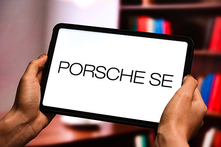 In this photo illustration, the Porsche SE logo is displayed on the screen of the tablet.