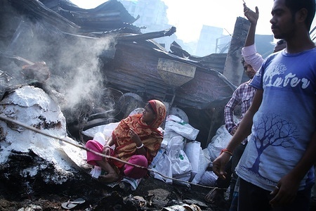A woman at her burnt house reacts in the the aftermath of the fire.
According to locals more than 100 shanties were completely destroyed as the fire broke out in a slum at Mohakhali area. Fire service said that this fire occurred due to electric shot circuits due to poor connection.
