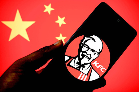 In this photo illustration, a KFC logo is seen displayed on a smartphone with the flag of China in the background.