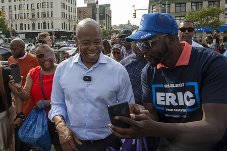 New York City Mayor Eric Adams, surrounded by supporters and media, walks on Harlem's 125th Street during a campaign event picking up the New York City African Council endorsement for re-election in Africa Square in Harlem on August 24, 2025 in New York City.