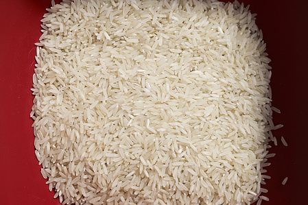 In this photo illustration, portion of raw white rice in a bowl seen displayed.