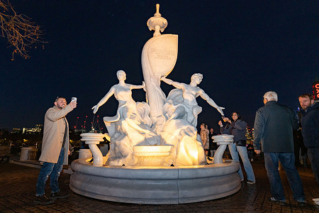 A crowd stands around the fountain. Visitors gathered around a temporary Peroni fountain on London’s South Bank, enjoying beer poured directly from the hand of a classical-style statue. The installation, created to celebrate the Italian beer, invited passersby to collect free pours of Peroni Nastro Azzurro while socialising along the riverside.