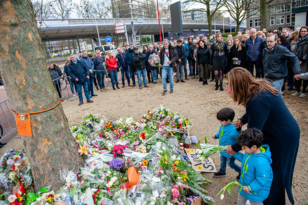 A woman with her children are seen laying flowers at the memorial site.
The day after three people were killed and five injured during a shooting on a tram in the Dutch city of Utrecht, hundreds of people have been placing flowers and letters of consolation during the whole day, at the Oktoberplein the place where the tram stopped and a man started shooting.