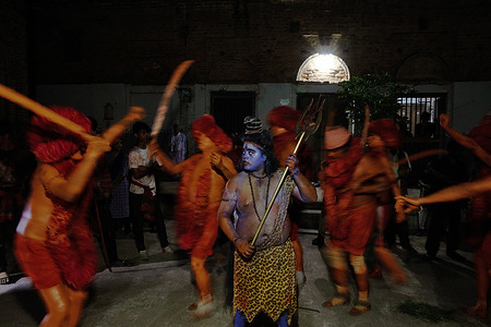 A Hindu devotees dancing after the Lal Kach procession at Munshiganj. The Hindu men paint themselves with red color and attend a procession holding swords as they show power against evil sprits in the very last day of Bangla calendar and welcoming another Bangla New Year at Munshiganj.