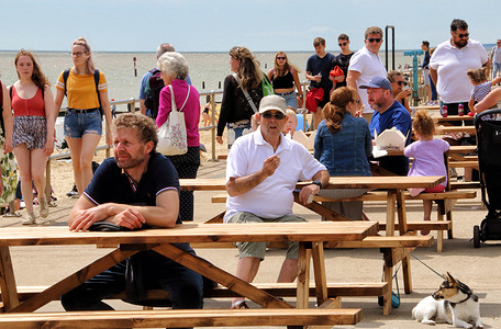 People sit at tables and observe Social distancing waiting for drinks to be served.
With the beaches in England now fully opened with only social distancing measures in force, people are taking the chance to visit some coastal resorts.
Southwold is an English resort town full of an olde world charm and famous for its 300 brightly coloured beach huts. Plenty of people were out and about on the sandy beach and on the pier.