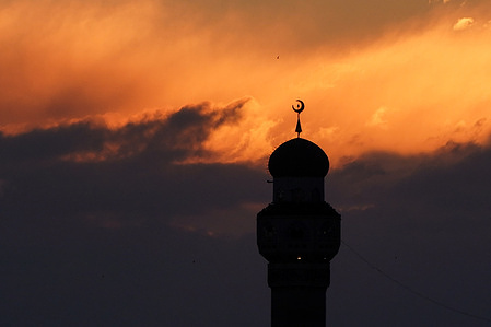 General view of the sunset behind the minaret of the Imam Mohsen Mosque in the city of Mosul northern Iraq.
