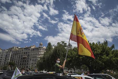 A protester in a car wearing a face mask as a preventive measure holds a Spanish flag during the demonstration.
Hundreds of cars and motorcycles have taken the streets in a motorcade against the Spanish government and public management of the Covid-19 crisis. The far-right party VOX demand the end of the confinement and the state of emergency since they consider that it limit the rights of the citizens.