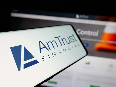 In this photo illustration, a smartphone with the logo of US company AmTrust Financial Services Inc. is seen on screen in front of website.