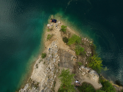 People stand in the rocks at zakrzowek lake in Krakow. Zakrzowek lake was created in 1990 after flooding an old limestone quarry . It consists of two tanks connected by an isthmus . The banks of the lagoon are one of the favorite places of recreation for the inhabitants of Krakow, however the bath in the lagoon is now prohibited due to the risk of drowning.
