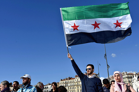 A protester holds a Syrian flag during the demonstration. Syrians in France demonstrated against Bashar al-Assad's attacks in Eastern Ghouta.