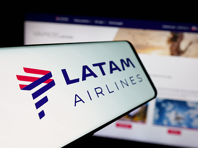 In this photo illustration, a smartphone with the logo of airline company LATAM Airlines Chile is seen on screen in front of website.