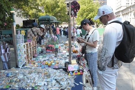 People are seen by vendors in City Hall Park in Manhattan, New York City.