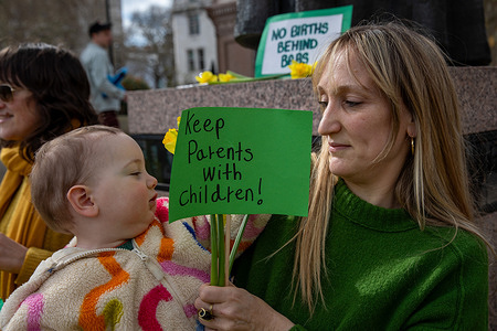 A mother holds her baby and a placard during a "No Births Behind Bars demonstration" in London. Campaigners gathered in Parliament Square on Mother's Day to call for an end to pregnant women giving birth in prison. The demonstration, held in-front of the Palace of Westminster, was organised as part of the No Births Behind Bars campaign led by Level Up. Supporters gathered with banners and signs urging the UK government to end the imprisonment of pregnant women and expand community alternatives to custody. The protest aimed to raise awareness and call for policy change to prevent babies being born behind bars.