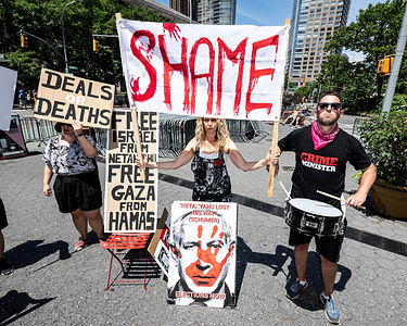 People holding signs and a banner at a Pro-Israel demonstration against Israeli Prime Minister Bibi Netanyahu and his government in Dante Park in New York City.